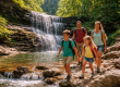 Family hiking near a waterfall while camping in the Finger Lakes in summer