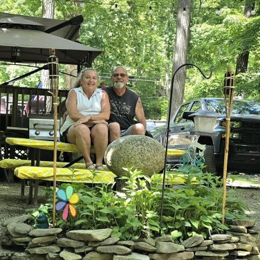 Couple relaxing at a decorated seasonal campsite at Sugar Creek Glen Camping in New York