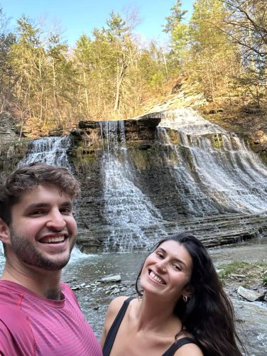 Couple smiling at a waterfall near Sugar Creek Glen Camping in New York