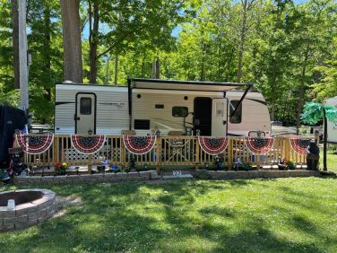 Seasonal RV campsite with decorated deck and outdoor space at a New York campground