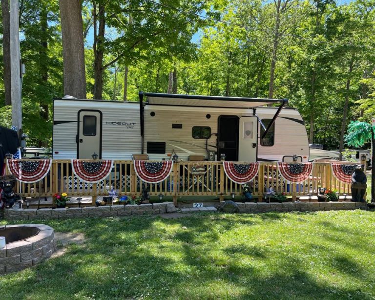 Seasonal RV campsite with decorated deck and outdoor space at a New York campground