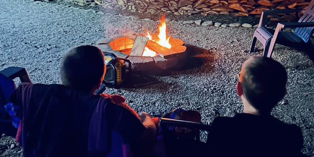 Two children relaxing beside a campfire during an evening at Sugar Creek Glen Campground