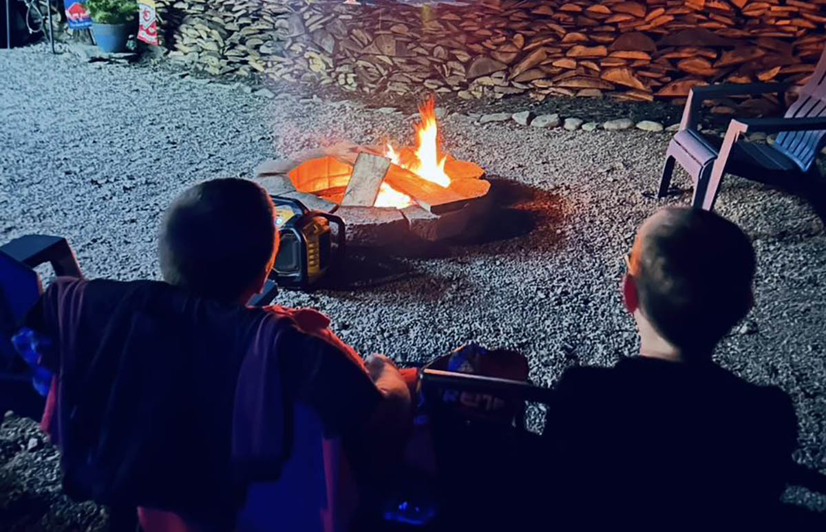 Two children enjoying a quiet evening around a campfire at Sugar Creek Glen Campground Two children relaxing beside a campfire during an evening at Sugar Creek Glen Campground