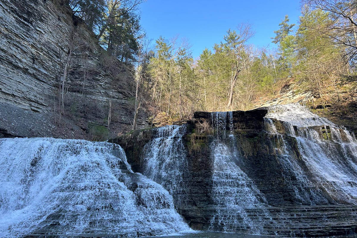 Natural waterfall cascading over layered rock formations at Sugar Creek Glen Campground near Dansville, NY.